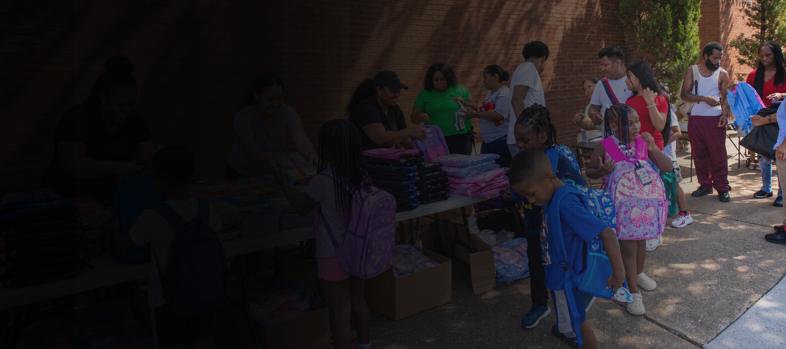 Children receiving backpacks and community resources through Savage Sports Community Development Corp.